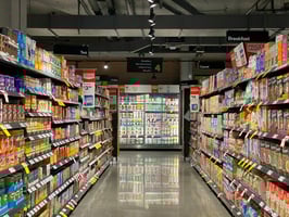 An aisle of a packed grocery store. Photo by Franki Chamaki on Unsplash.