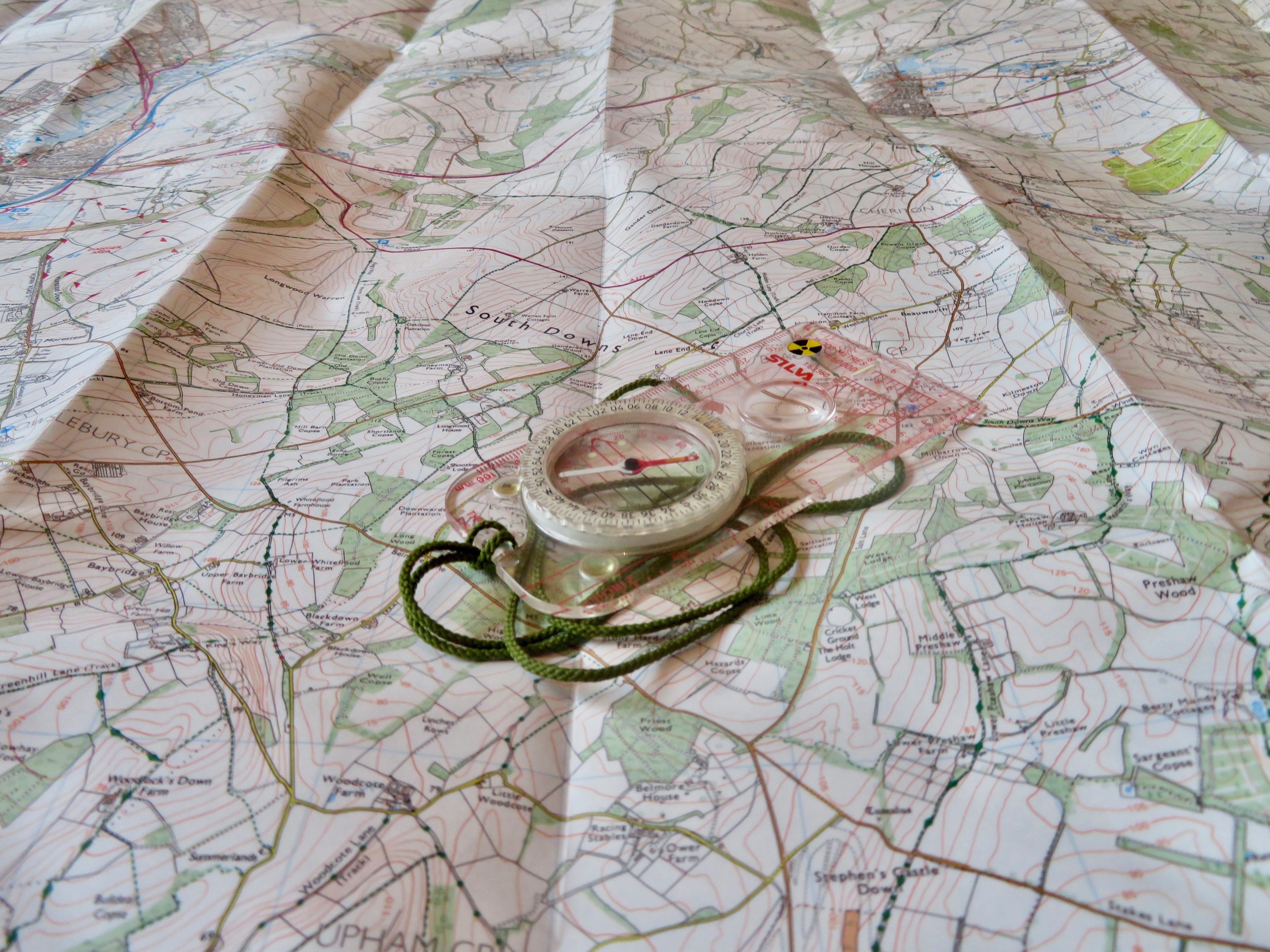An open map with a compass set atop. Photo by Simon Harmer on Unsplash